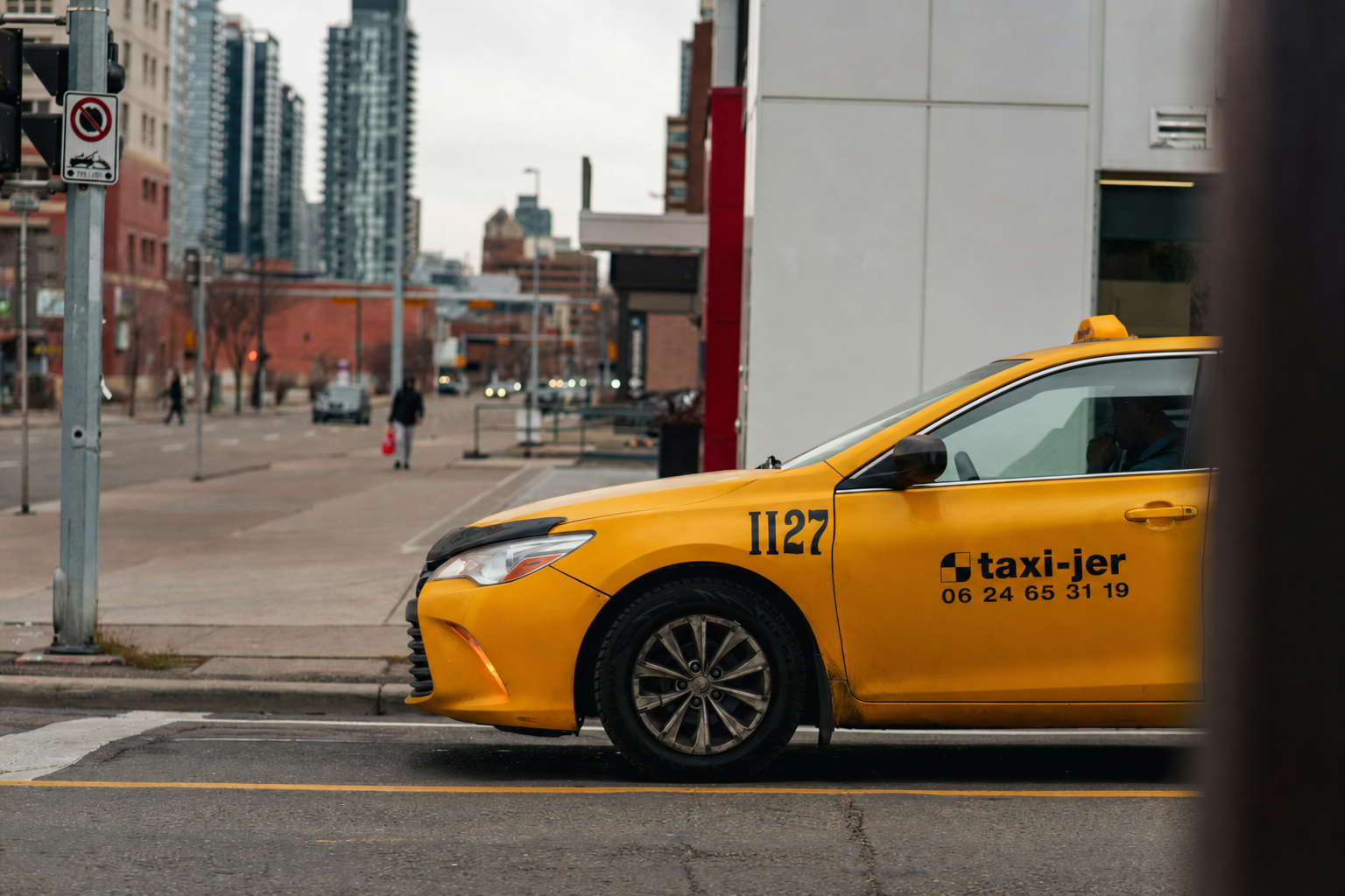 Gele taxi van Taxi Jer op route door de stad